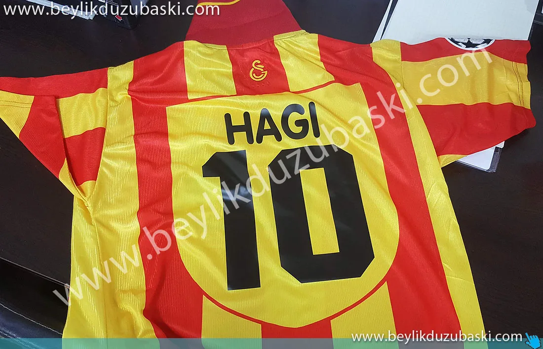 aslına-uygun-forma-baskısı-hagi-için-galatasaray-forma-baskısı-nostaljik-forma-baskısı-müşteri-talebine-göre-özel-tasarlanmış-forma-numara-ve-isim-baskısı-örneğidir.jpg forma baskı, forma üzerine yazı baskı, formaya numara baskı, hızlı üretim yapılır, bekle ve al desteklenir, 1 adet için üretim yapılır, forma müşteri getirir