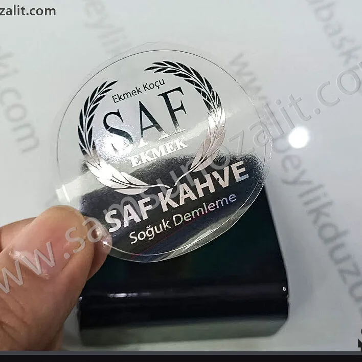 şeffaf etiket baskı, cam üzerine yapıştırılmış örnek ürün, adet ve ebada göre fiyat alınız, şeffaf etiket baskı merkezi kopya, şeffaf etiket baskı, varak yaldız baskı, kaliteli baskı, aynı gün gönderim, tasarım desteği, hızlı ürerim, dijital baskı merkezi, şefaf etiket baskı, yaldız baskı, varak yaldız baskı, kaliteli baskı, aynı gün gönderim, acil üretim, tasarım desteği baskı, gerçek ayna görünümlü, varak baskı etiket kopya